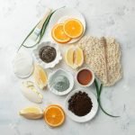 Homemade skin care and body scrubs and mask with natural ingredients aloe vera, lemon, coffee, oranges, clay, honey set up on white wooden background with flat lay